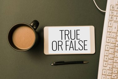 Text caption presenting True Or False, Word Written on Decide between a fact or telling a lie Doubt confusion Phone Screen With Important Message On Desk With Keyboard, Pen And Coffee.