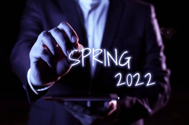 Sign displaying Spring 2022, Business idea time of year where flowers rise following winter season Hand With Pen Pointing Important Infortmations With Other Holding Tablet