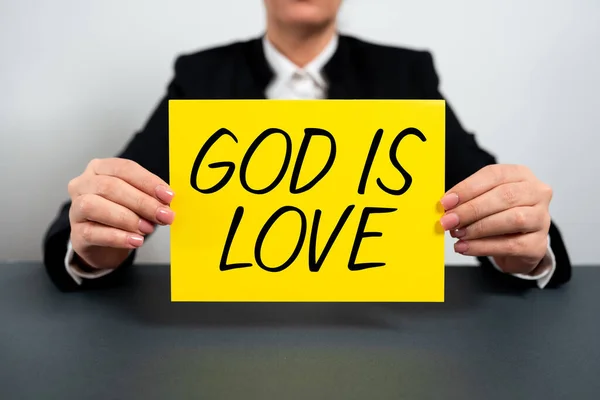 Text showing inspiration God Is Love, Concept meaning Believing in Jesus having faith religious thoughts Christianity Businesswoman Holding Note With Important Message On Office Desk.