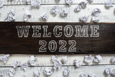 Writing displaying text Welcome 2022, Word for New Year Celebration Motivation to Start Cheers Congratulations Important Ideas Written On Piece Of Wood With Paper Wraps Around On Floor.