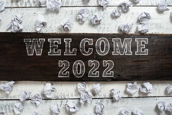 Writing displaying text Welcome 2022, Word for New Year Celebration Motivation to Start Cheers Congratulations Important Ideas Written On Piece Of Wood With Paper Wraps Around On Floor.