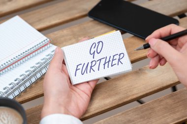 Conceptual caption Go Further, Word for To move to a greater distance or overcome your limitations Businesswoman Holding Pen And Notepad With Important Message.