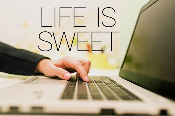 Text sign showing Life Is Sweet, Word for Happiness seeing the good side of events Motivation Inspire Businesswoman Typing Recent Updates On Lap Top Keyboard On Desk.