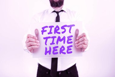 Conceptual caption First Time Here, Business approach Never been in this place before special treatment for new Businessman With Placard Presenting Important Strategies For Progress.