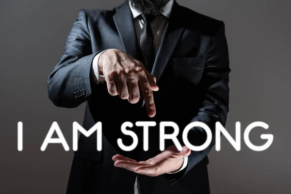 Conceptual caption I Am Strong, Concept meaning Have great strength being healthy powerful achieving everything Businessman In Suit Pointing With One Finger On Important Message.