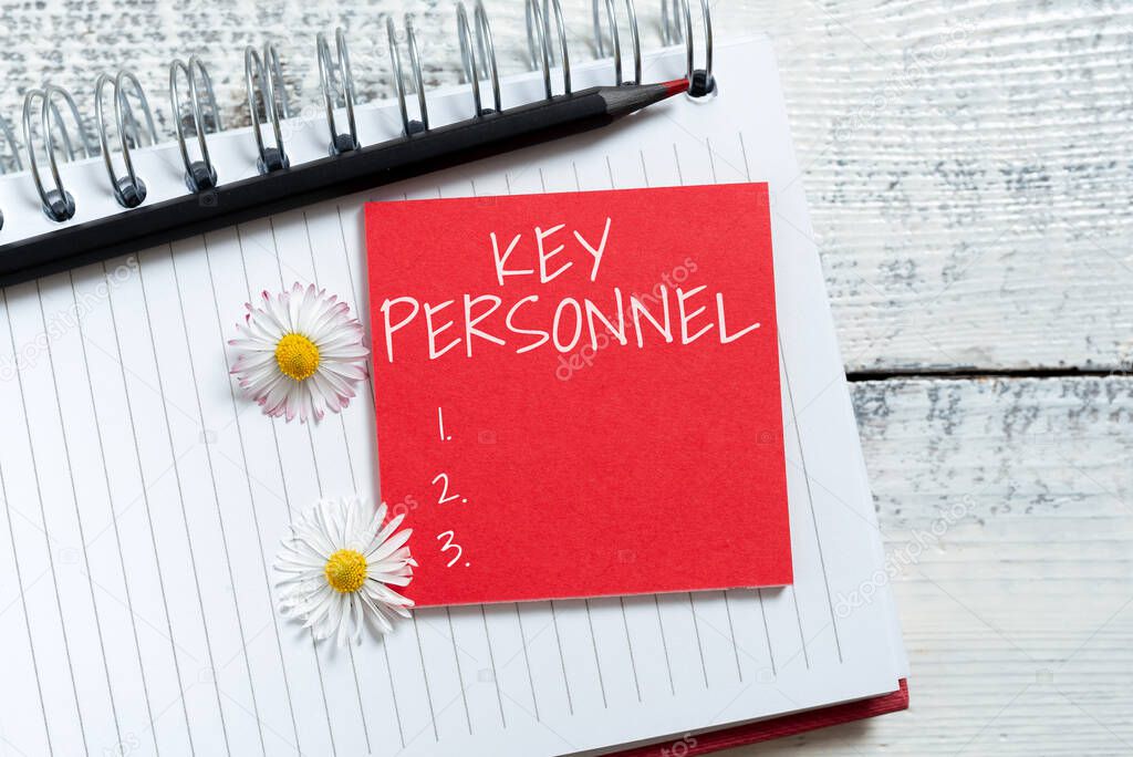 Hand writing sign Key Personnel, Business approach Program Directors Principal Investigator Project Executives Sticky Note With New Ideas Over Notebook With Pencil And Flowers Around.