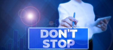 Sign displaying Don T Not Stop, Business concept Continue what had been doing without rendering a delay Businessman in suit holding tablet symbolizing successful teamwork.