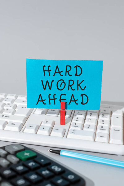 Text sign showing Hard Work Ahead, Internet Concept A lot of job expected big challenge activities required Important Message Presented On Piece Of Paper Clipped With Clip.