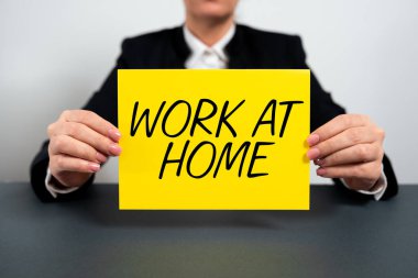 Conceptual caption Work At Home, Internet Concept Freelance job working on your house convenient technology Businesswoman Holding Note With Important Message On Office Desk.