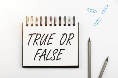 Doğru ya da Yanlış metni gösteren yazılar yazmak, kavramsal fotoğraf bir gerçek ya da yalan söylemek arasında karar vermek takım elbiseli bir işadamının elinde başarılı takım çalışmasını simgeleyen tablet bulundurması şüphesi.