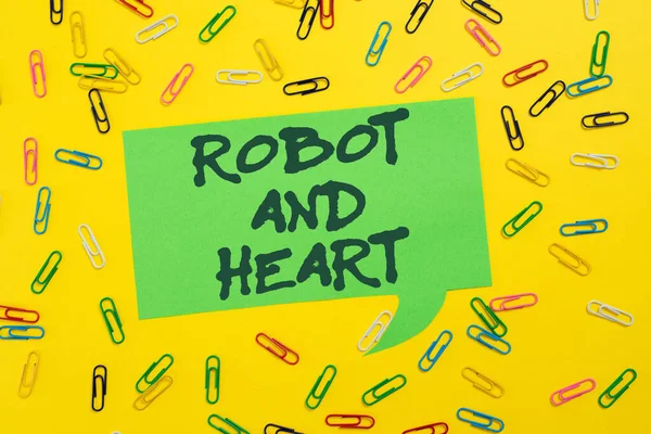 Text caption presenting Robot And Heart, Conceptual photo Sensitivity and care behind the machine technology