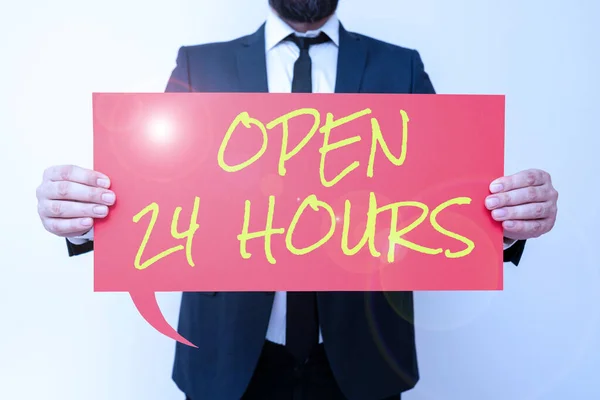 Hand writing sign Open 24 Hours, Word for Working all day everyday business store always operating Businessman in suit holding open palm symbolizing successful teamwork.