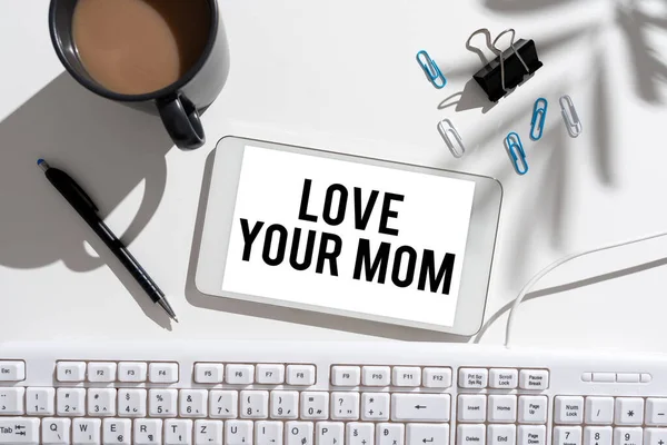 Text showing inspiration Love Your Mom, Concept meaning Have good feelings about your mother Loving emotions Businesswoman Presenting Important Message On Mobile Phone Screen On Desk.