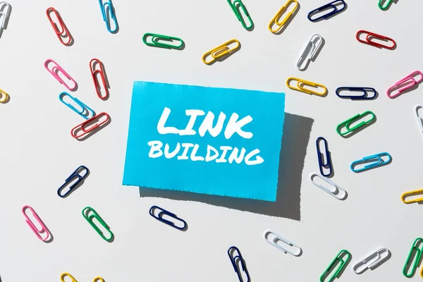 Handwriting text Link Building, Business concept Process of acquiring hyperlinks from other websites Connection Piece Of Paper With Important Message Surrounded By Colorful Paperclips.