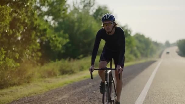 Ciclista masculino em passeios de capacete bicicleta ao longo da pista, supera muito acima — Vídeo de Stock