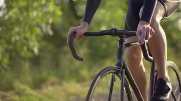 Oříznutý pohled mužský cyklista jezdí na kole podél silnice — Stock video