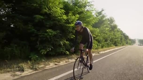 Profesionální cyklista v helmě jezdí na kole po prázdné trati — Stock video