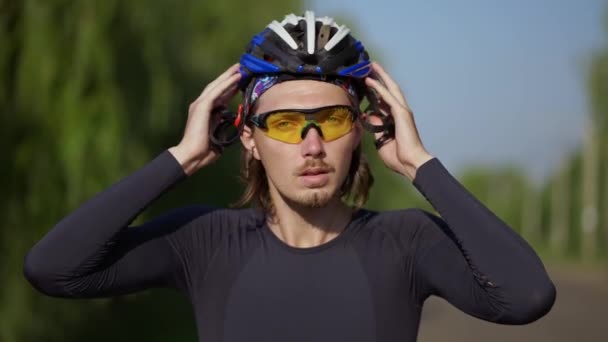 Deportista poniéndose el casco en bicicleta, de cerca — Vídeo de stock