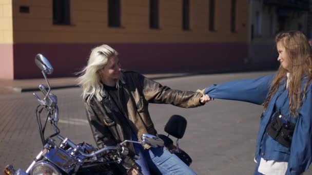 Twee jonge vrouwen verliefd en gemonteerd motorfiets in de stad, plezier hebben samen — Stockvideo