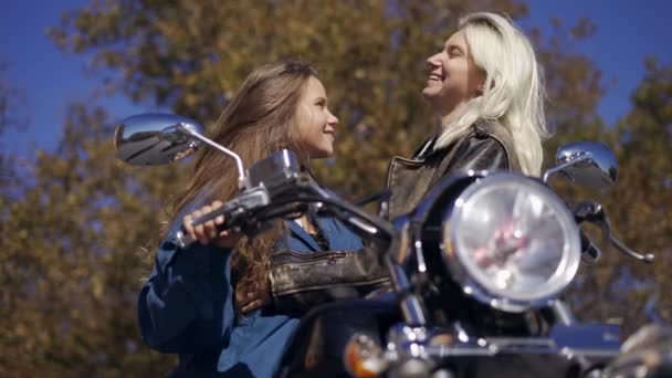 Twee millenial meisjes zoenen, genieten van elkaar op de gemonteerde fiets — Stockvideo