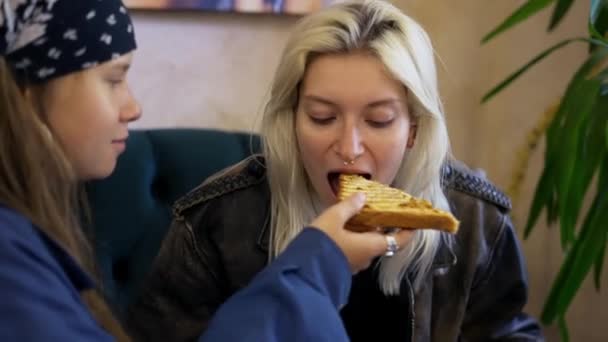 Cheerful lesbian girls in confectionery, feeding each other — Stock Video