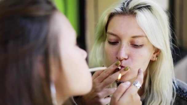 Deux filles allumant leur cigarette roulée à la main, profitant d'une cigarette à l'extérieur — Video