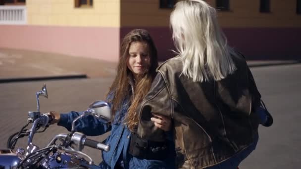 Dos mujeres europeas enamoradas se sientan en motocicleta, abrazando — Vídeos de Stock