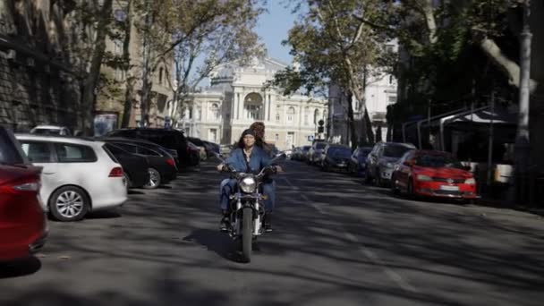 Дві європейські жінки їдуть на мотоциклі по міській вулиці — стокове відео