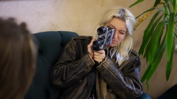 Uma garota no café atirando em sua namorada com câmera retro — Vídeo de Stock