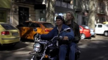 Yazın şehir sokağında motosiklet sürmekten zevk alan iki genç kadın.