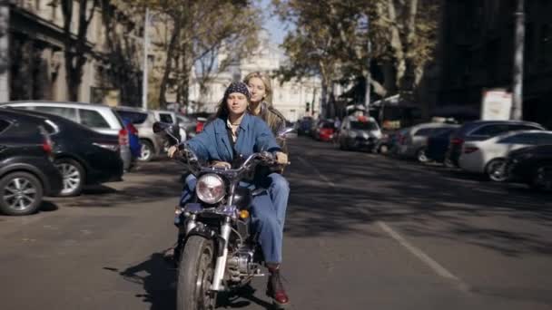 Twee millenial meisjes zoenen met passie, terwijl stoppen op het stoplicht op motobike — Stockvideo
