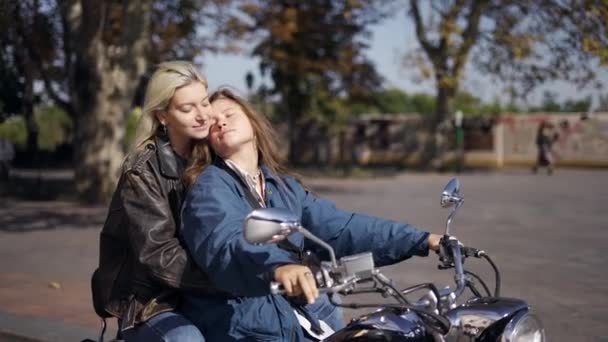 Lesbiennes amoureuses assis sur une moto dans la rue de la ville — Video