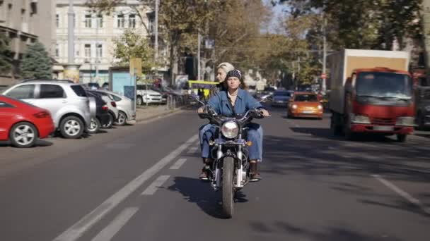 两个欧洲女人骑着摩托车经过城市街道，站在前面看 — 图库视频影像