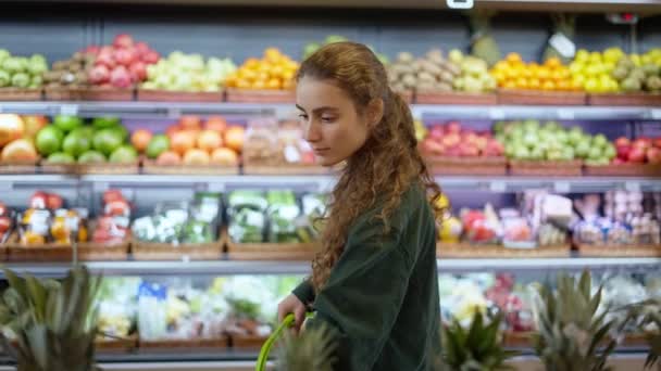 Cliente femenino que compara diferentes frutas en el mostrador de alimentos — Vídeos de Stock