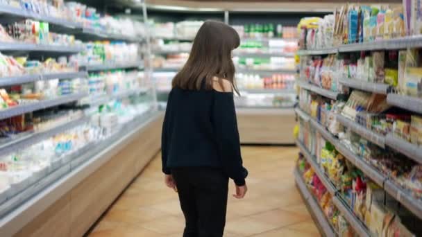 Wesoły nastolatek w supermarkecie, biorąc słodycze z półki — Wideo stockowe