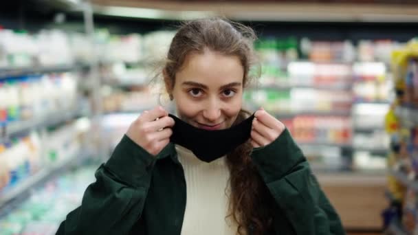 Femme acheteur fait des achats pendant l'épidémie de coronavirus, mettre son masque de protection — Video