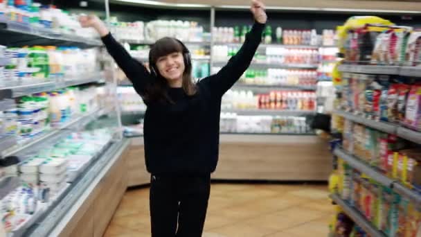 在超级市场快乐的青少年戴着耳机跳舞 — 图库视频影像