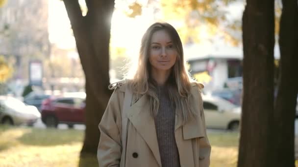 Blond glimlachende vrouw buiten in lens fakkels in de herfst — Stockvideo