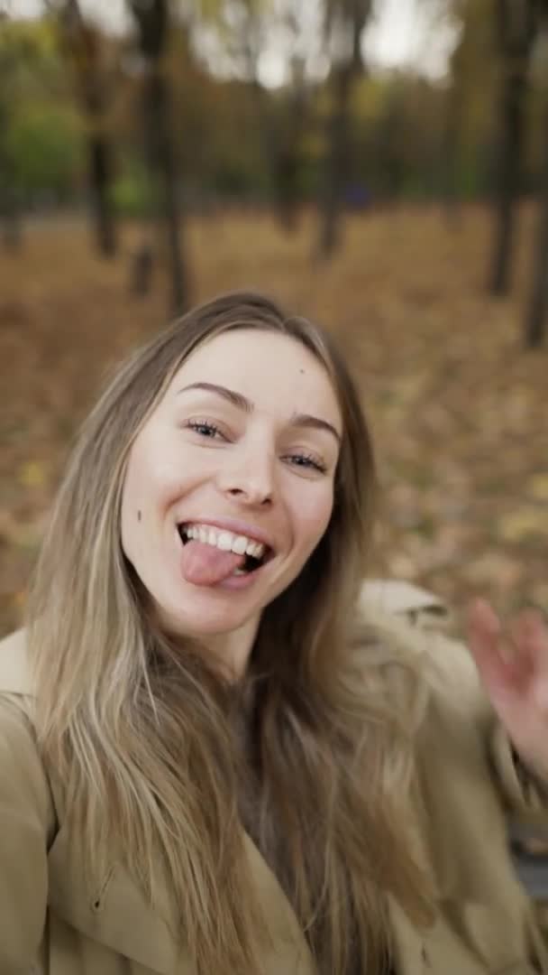 Blonde Frau macht Selfie-Foto mit Smartphone im Park beim Spazierengehen — Stockvideo