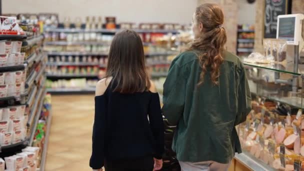 Adolescente et sa mère faisant du shopping au supermarché, vue arrière — Video