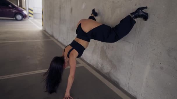 Sexy dívka představení twerk tanec stojící vzhůru nohama opírající se o zeď