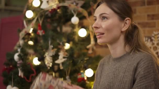 Mulher loira tremendo caixa de presente de Natal adivinhando o que dentro, close-up — Vídeo de Stock