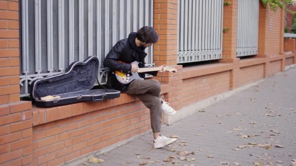 Killen som spelar på giutar på gatan — Stockvideo