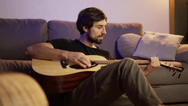Man spelar på gitarr hemma — Stockvideo