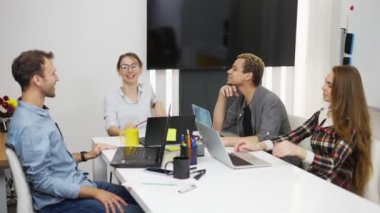 Ofiste dizüstü bilgisayarları olan genç yaratıcı iş adamları projeyi dağıtıyor.