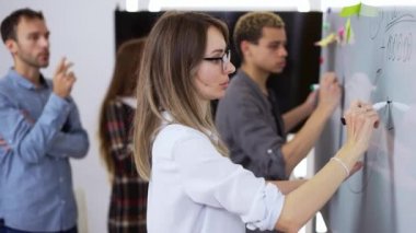 Çeşitli finans bürosu çalışanları kurumsal eğitim alıyorlar ve beyaz tahta kullanıyorlar.