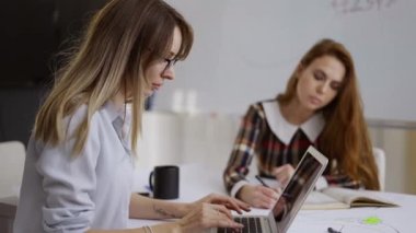 Ofiste laptopları olan konsantre genç iş adamları, her zamanki iş günü.