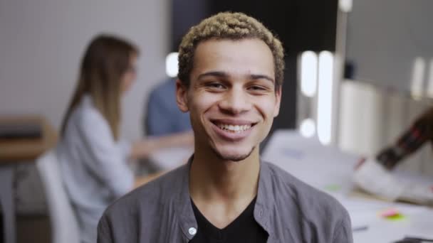 Portret van een gelukkige zakenman, een goed uitziende gemengde racer die op kantoor staat, kijkend naar de camera — Stockvideo