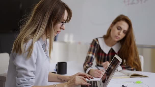 Concentrated young business people with laptops in the office, usual work day — Stock Video