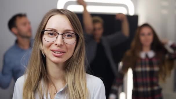 Joven empresaria en una fiesta de empresa, mirando y sonriendo a la cámara — Vídeos de Stock